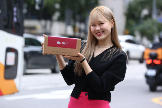 방송인 엄지윤이 유플러스닷컴 사전예약 고객인 김민선씨에게 '아침배송'으로 아이폰16 프로를 전달하고 있다. LG유플러스 제공